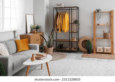 Interior of living room with shelving unit, clothes and sofa - Shutterstock ID 2311328835
