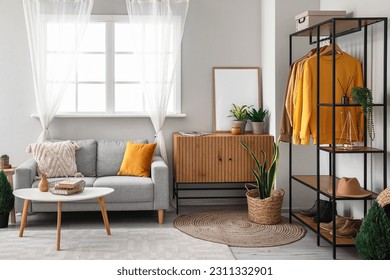 Interior of living room with shelving unit, clothes and sofa - Shutterstock ID 2311332901