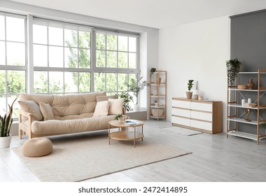 Interior of living room with soft couch, table and big window