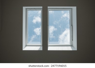 Interior low angle view at closed white Tilt Window Skylights at attic and background of sunny blue sky. - Powered by Shutterstock