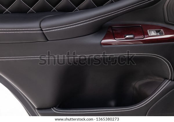 Interior of a\
luxury car with leather interior overtightened stitching in the\
form of a diamond of white thread at door trim in a vehicle repair\
shop. Design atelier auto\
service.