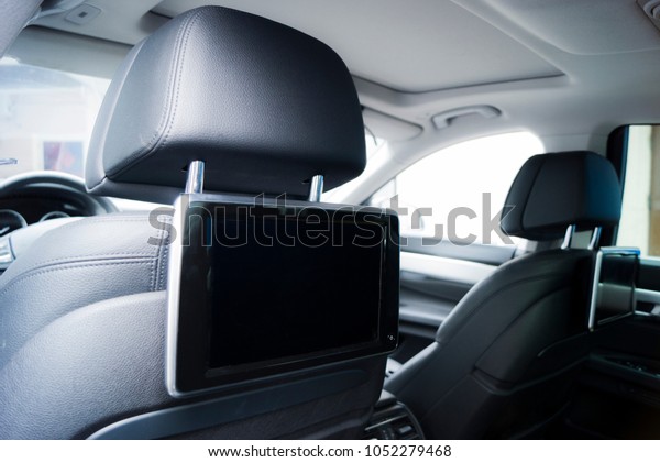 Interior of\
a luxury car. TV screen inside of the\
car