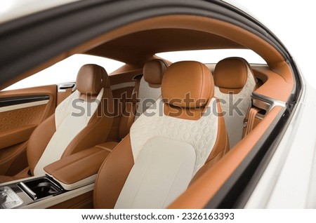 interior of a luxury sports coupe comfortable seats with milky and orange leather trim