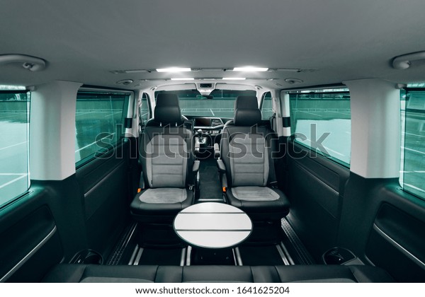Interior of luxury vip van with comfortable leather\
seats and table