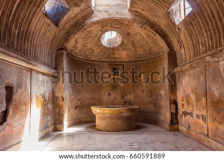 The interior of main public baths in ruins of Ancient Roman city Pompeii, Campania region, Italy. Sunny day. City destroyed by the eruption of Mount Vesuvius. Inside of Forum Baths. Big bowl for water