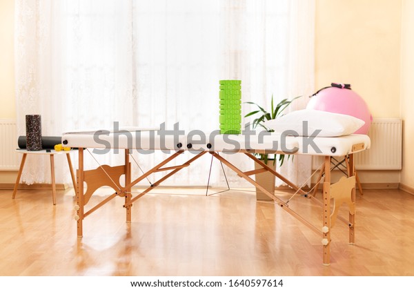 Interior of a massage or physical therapy\
treatment room with examination\
table.