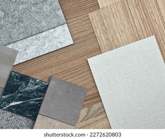 interior material board containing multi pattern of wooden laminateds, grainy quartz stones, grey interior fabric wallpaper, green marble, artificial stone samples. close up or macro view. mood board.