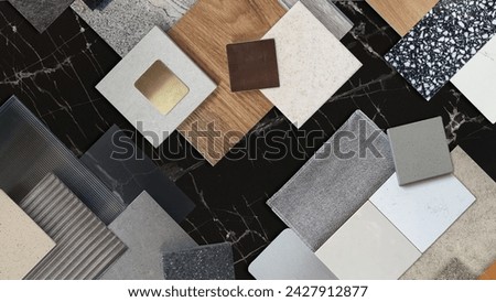 interior material samples contains panels and tiles. interior moodboard including terrazzo, quartz, stone tiles, blue laminated, wooden flooring tiles, gold stainless placed on black marble table.