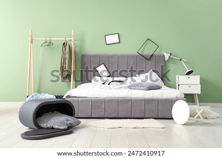 Interior of messy bedroom with frames and clothes rack