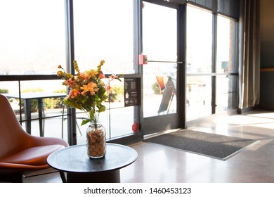 Interior Midcentury Style Lounge Of A Coffee Shop With View Of Parking Lot And Outside Seating.  Wide Shot Of Store Entryway Door.