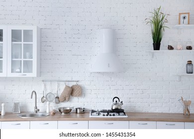 Interior of minimalistic kitchen with white walls, white floor, white countertops. Kitchen with white furniture.
