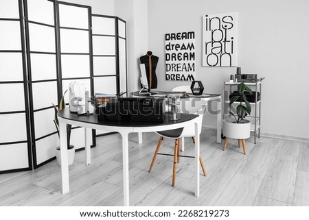 Interior of modern atelier with tables and mannequin