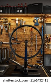 Interior of modern bicycle garage or workshop with different professionals tools and equipment. Bike service, repair and upgrade. Broken cycling wheel on table for fixing, installing or replacement