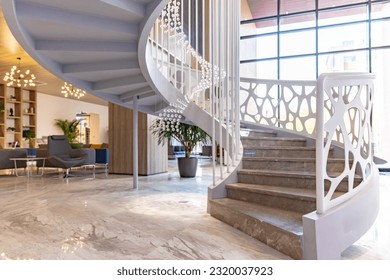 Interior of modern building lobby with spiral staircase - Shutterstock ID 2320037923