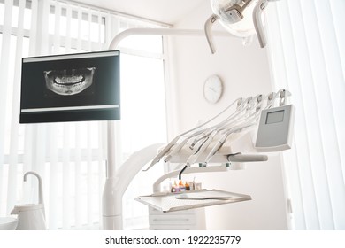Interior of modern dentist cabinet and medical chair. Stomatology cabinet with nobody in it and white equipment for oral treatment. Interiors concept - Shutterstock ID 1922235779