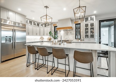 Interior modern farmhouse kitchen and dining room with white countertops bar stools large dining table stainless appliances and view to living room with vaulted ceiling - Powered by Shutterstock