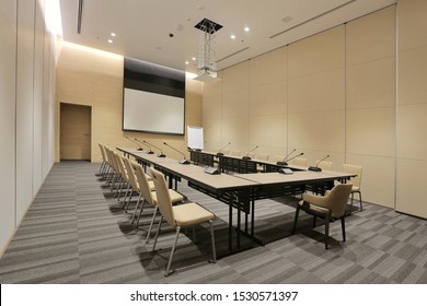 Interior Of Modern Fully Equipped Professional Facilities Meeting Conference Room Boardroom Classroom Office With Nobody Empty And  Microphones White Projector Board Chairs Door Business Meeting Venue