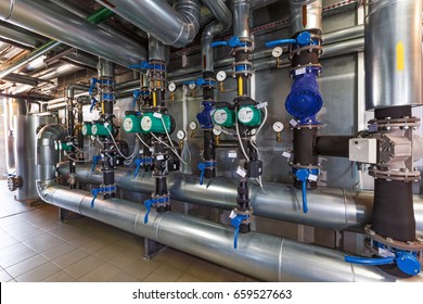 The interior of a modern gas boiler house with pumps, valves, a multitude of sensors and barrels.