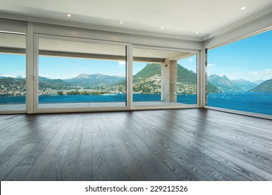Interior, modern house, empty living room with windows overlooking the lake
