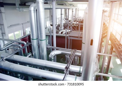 The interior of a modern industrial gas boiler room. Pipelines, water pumps, valves, manometers