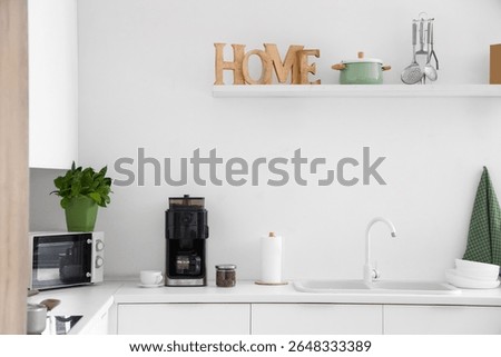 Interior of modern kitchen with coffee machine on white counter