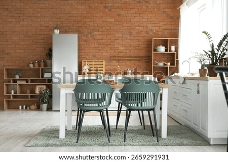 Interior of modern kitchen with dining table and fridge