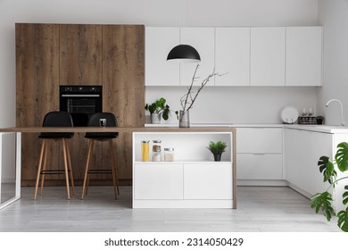 Interior of modern kitchen with island, built-in oven and white counters - Powered by Shutterstock