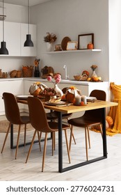 Interior of modern kitchen with served dining table and pumpkins