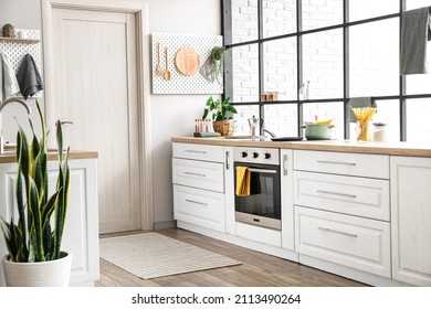 Interior Of Modern Kitchen With White Counters, Door And Peg Boards