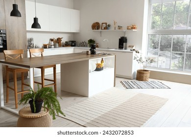 Interior of modern kitchen with white furniture, houseplant and wooden island table - Powered by Shutterstock