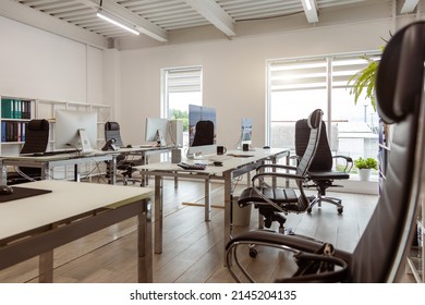 Interior of a modern light small company office. Workspace, office stationery and business environment comfort for interaction and development - Shutterstock ID 2145204135
