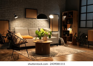 Interior of modern living room with grey sofa, wooden coffee table and glowing lamps at evening - Powered by Shutterstock