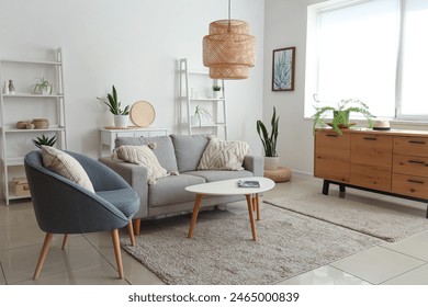 Interior of modern living room with grey sofa, coffee table and armchair