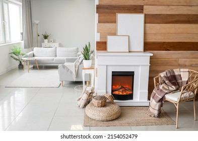 Interior Of Modern Living Room With Mantelpiece, Firewood And Frames