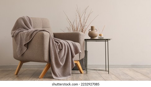 Interior of modern living room with soft armchair, table and plaid - Shutterstock ID 2232927085