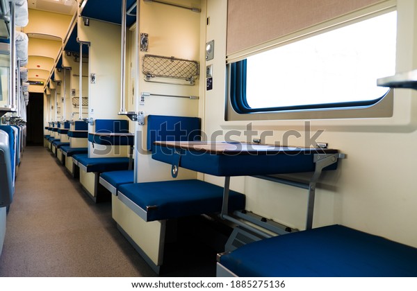 Interior of a modern long-distance train\
with empty seats in a comfortable sleeping\
car