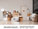 Interior of modern office with cardboard boxes, furniture and monitor wrapped in film on moving day