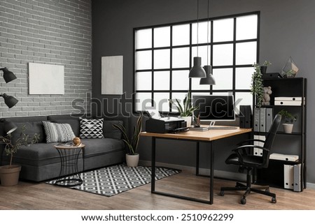 Interior of modern office with workplace, printer and sofa