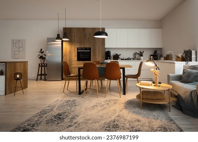 Interior of modern open plan kitchen with dining table and glowing lamps