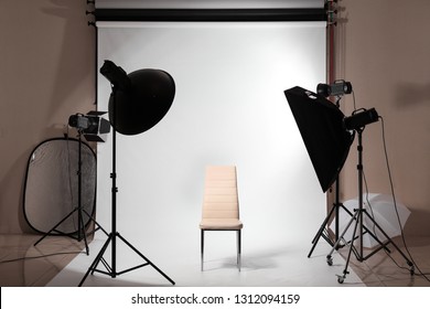 Interior Of Modern Photo Studio With Professional Equipment And Chair