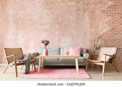 Interior of modern room with sofa, armchairs and wooden table near color wall