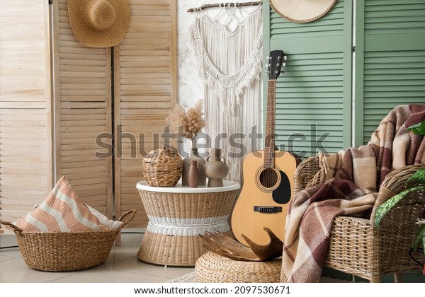 Interior of modern room with stylish chair, guitar\
and folding screen