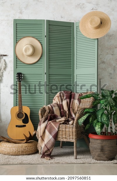 Interior of modern room with stylish chair, guitar\
and folding screen