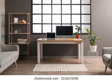Interior Of Modern Room With Workplace And Shelving Unit
