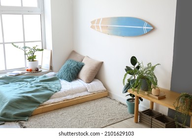 Interior Of Modern Stylish Bedroom With Surfboard Hanging On Wall