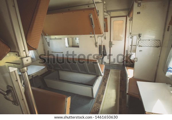 Interior of Moldovan sleeping train\
wagon. Visible aisle and sleeping quarters on left and right,\
during a trip through the country. Sleeping on a\
train.