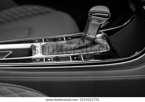 The interior of a new car.\
Automatic transmission in leather trim. Black and white\
photo	