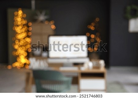 Interior of office with programmer's workplace decorated for Christmas, blurred view