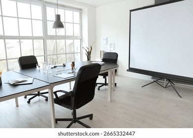 Interior of office with table and projector screen prepared for meeting