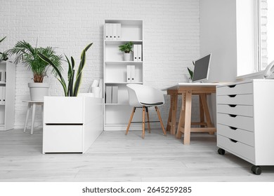 Interior of office with table, shelf unit and plants